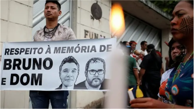A demonstrator holds a banner reading "In respect of the memory of Bruno and Dom" during a protest following the disappearance of British journalist Dom Phillips and indigenous expert Bruno Pereira
