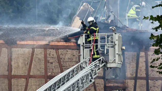 A firefighter sprays water on a building after a fire in a home for disabled people in Wintzenheim