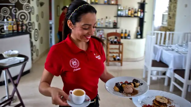 Una camarera soriente y vestida de rojo... propina a la vista