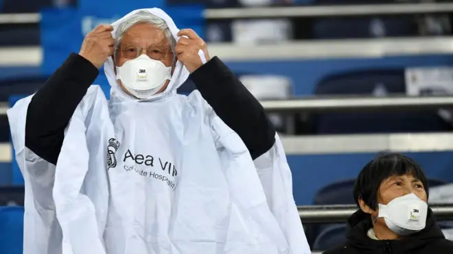 Fans wear 3M Aura Disposable Respirators as they await kickoff prior to the Liga match