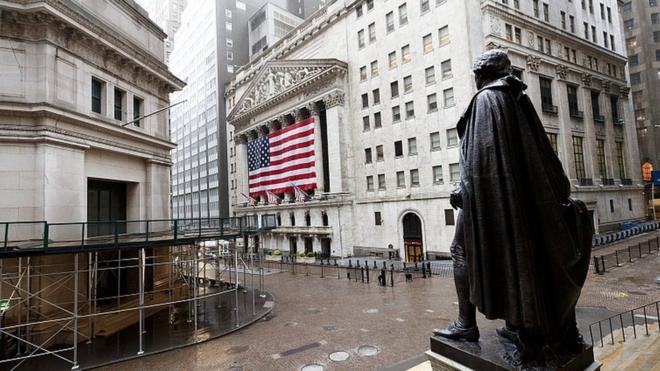 A quiet Wall Street with a view of a statue of George Washington and the New York Stock Exchange in New York, 13 April 2020