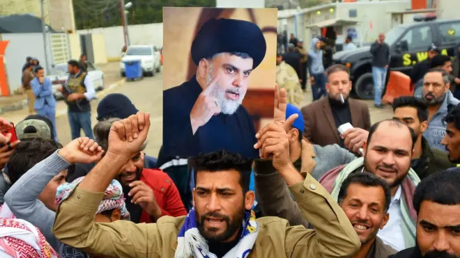 Supporter holds portrait of Moqtada al-Sadr, Najaf, Iraq (07/12/19)