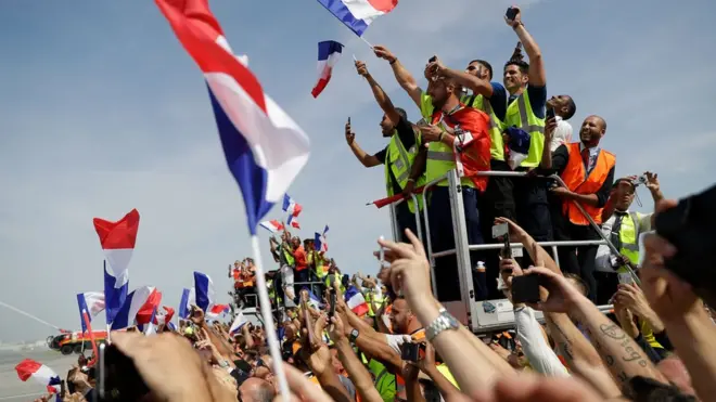 Толпы болельщиков собрались в парижском аэропорту Руасси - Шарль-де-Голль, чтобы приветствовать игроков сборной