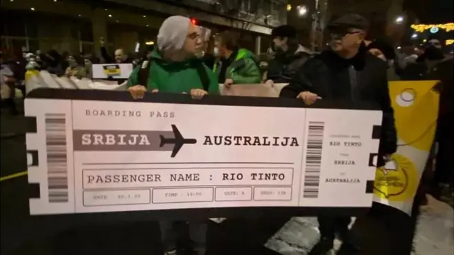 Гигантский билет - намек на то, что Новака Джоковича недавно депортировали из Австралии, а теперь Сербия высылает целую корпорацию