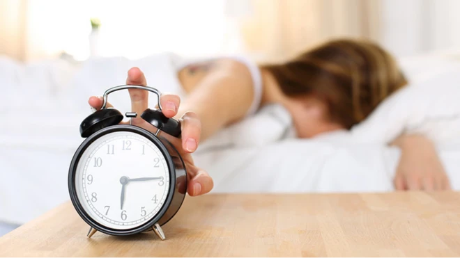 รูปผู้หญิงเอื้อมมือกดนาฬิกาปลุก