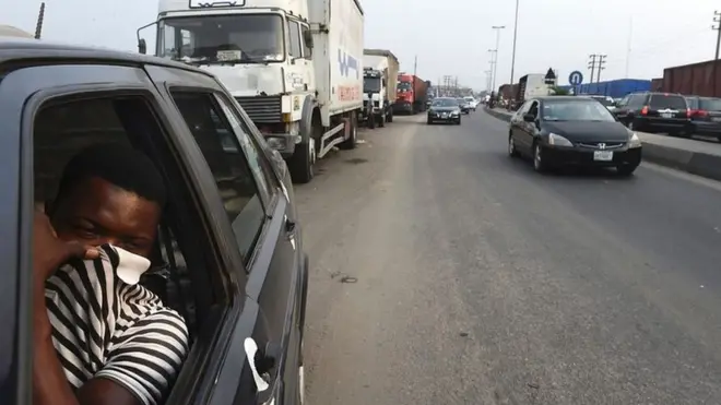 A man uses his shirt to cover his nose from the polluted air