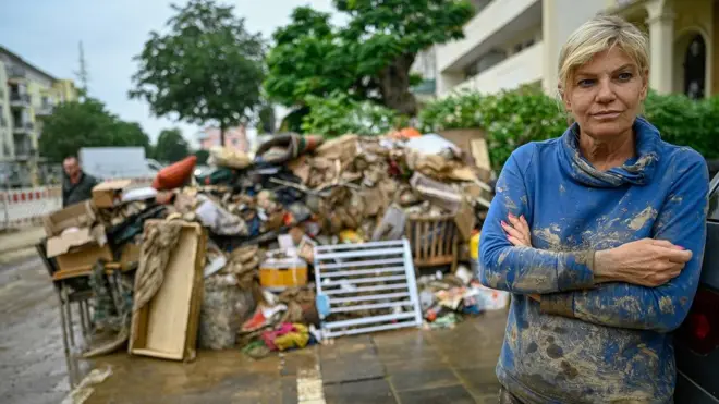 A resident in the Rhineland-Palatinate district of Ahrweiler stands in front of her property destroyed by a flood on 16 July 2021