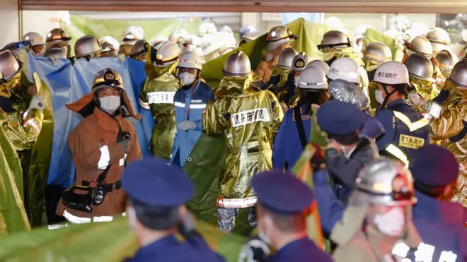 Rescue workers and police officers work at the site where a knife, arson and acid attack incident occurred on a train, at the Kokuryo station of the Keio Line train in Tokyo, Japan, October 31, 2021