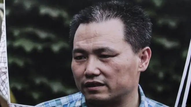 A pro-democracy protester holds a portrait of Chinese human rights lawyer Pu Zhiqiang, demanding his release during a demonstration outside the Chinese liaison office in Hong Kong (16 December 2015)