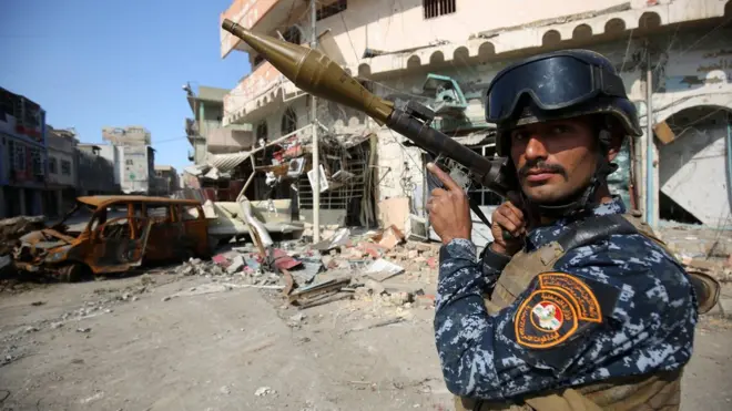 Binh lính quân đội Iraq tiếp cận mục tiêu tấn công nhắm vào quân IS đang 'lẩn khuất' trong các khu nhà của cư dân.