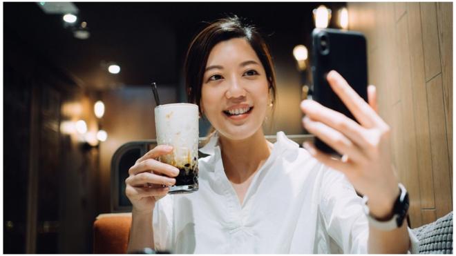 一名香港女子拿著珍珠奶茶自拍