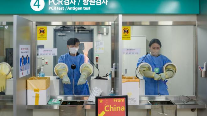 2023/01/02: Quarantine officials seen preparing for a PCR test for travelers arriving from China in COVID-19 testing station at Incheon International Airport, west of Seoul