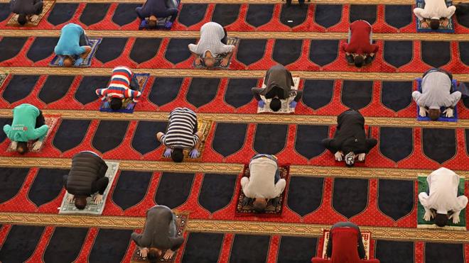 Worshippers pray whilst social distancing