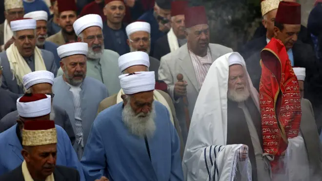 أحد كهنة الطائفة السامرية حاملا لفائف التوراة خلال صلاة في جبل جرزيم، قرب نابلس بالضفة الغربية