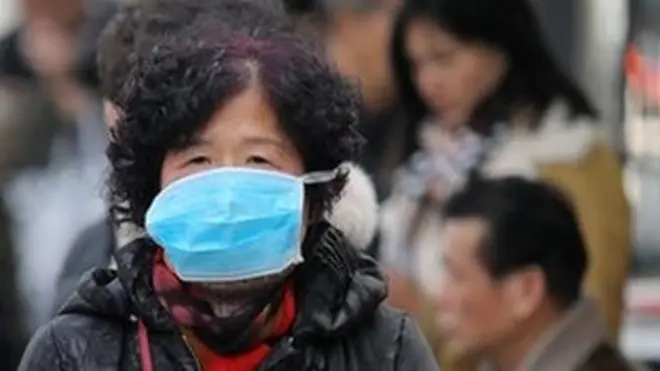 Chinese residents wear masks at a bus station near the closed Huanan Seafood Wholesale Market