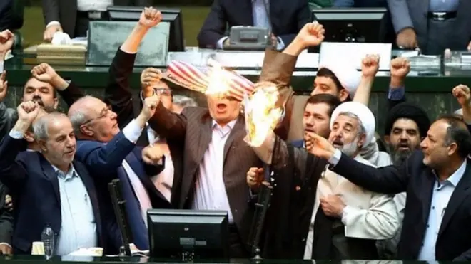 مجموعة من السياسيين الإيرانيين تحرق علمًا أمريكيًا في برلمان