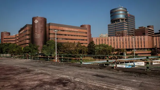 A general view shows an empty bridge where clashes between protesters and police previously took place, outside the Hong Kong Polytechnic University (back) where dozens of pro-democracy protesters remain holed up inside, in the Hung Hom district of Hong Kong on November 21, 2019