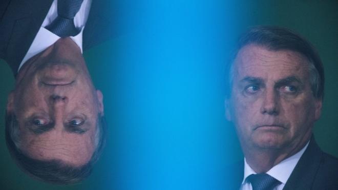 Bolsonaro com feição séria e reflexo