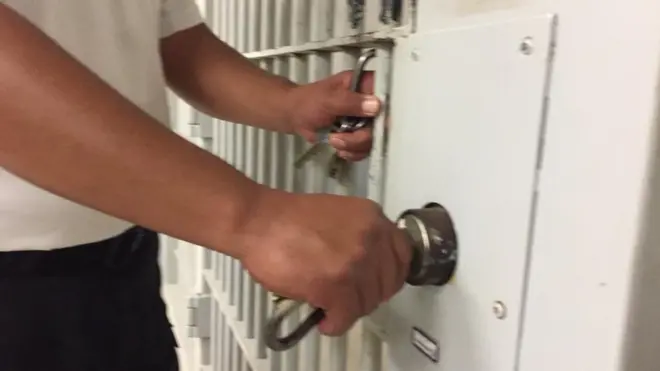 Custodio cerrando una puerta.