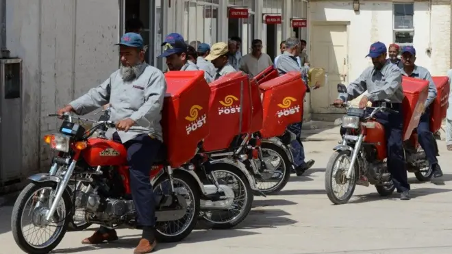 A group of Pakistani Postmen starting their mail delivery in motorbikes