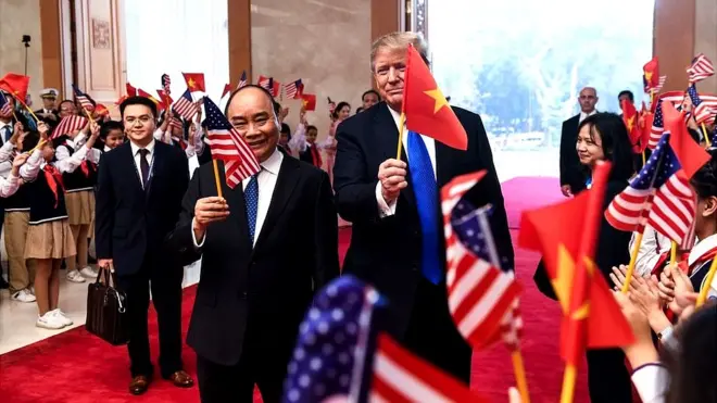 Tổng thống Mỹ Donald Trump cầm cờ Việt Nam và Thủ tướng Việt Nam Nguyễn Xuân Phúc cầm cờ Mỹ tại Văn phòng Chính phủ VN ở Hà Nội ngày 27/2/2019, trước thượng đỉnh Mỹ - Triều