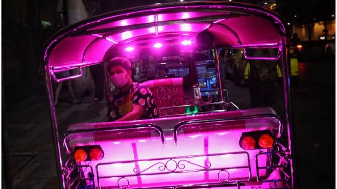 A tuk tuk driver wearing a protective facemask waits for passengers outside the Chatuchak weekend market in Bangkok on February 8, 2020