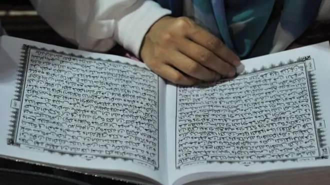 File photo: A woman reads a copy of the Koran