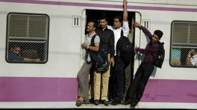 ट्रेन के दरवाज़े पर लटके यात्री