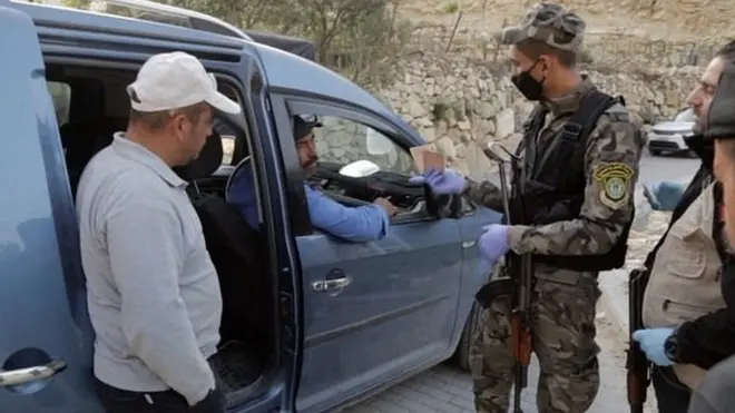 Petugas keamanan Palestina memeriksa pekerja yang ingin melintas ke Israel untuk bekerja.