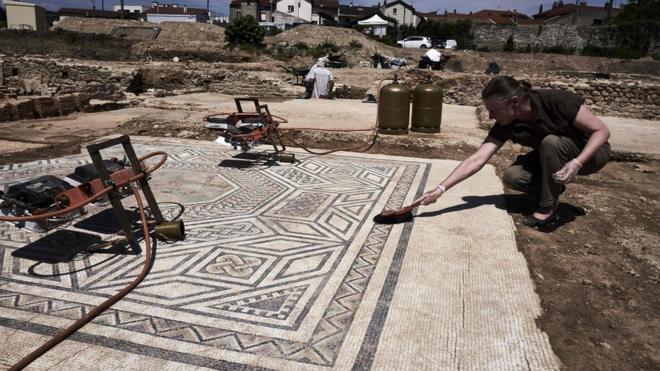 An archaeologist works on a mosaic near Vienne, south-eastern France, 31 July