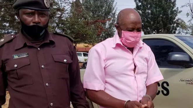 Paul Rusesabagina, portrayed as a hero in a Hollywood movie about Rwanda"s 1994 genocide, is escorted in handcuffs into a courtroom, in Kigali