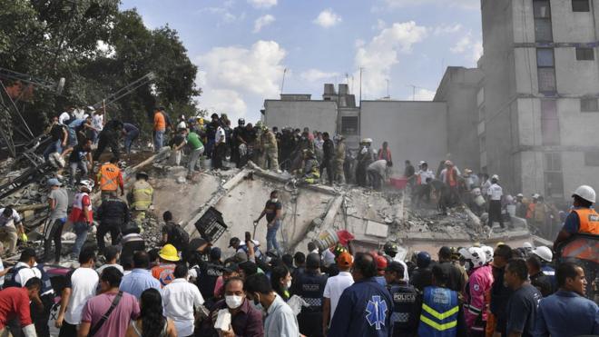 救援人員和志願者在瓦礫中搜尋倖存者。