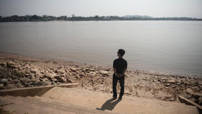 คิม ฮัก มินยืนอยู่ริมแม่น้ำโขง ใกล้กับบริเวณที่เขาขึ้นเรือเหยียบเมืองไทยเป็นครั้งแรก