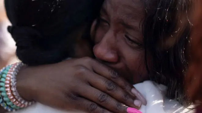 Mujeres llorando en una vigilia tras el tiroteo en Buffalo.