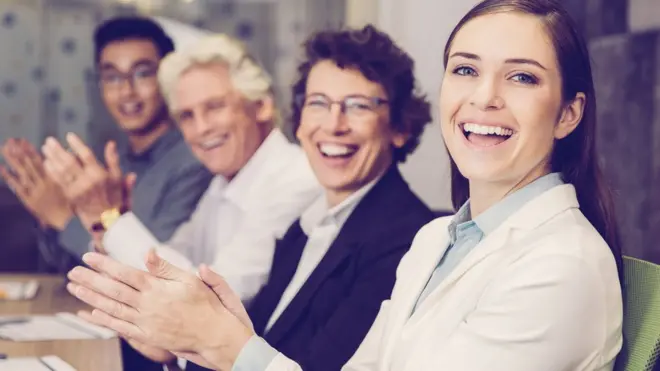 Colegas riéndose y aplaudiendo