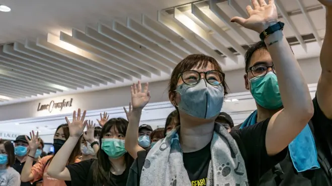 示威者在商場上舉起手，表達對"五大訴求"的堅持。