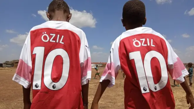 Lawrence na kakake wakiwa wamevaa fulana walizopewa na Mesut Ozil