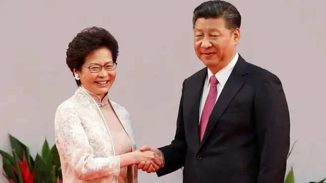 Carrie Lam berjabat tangan dengan Presiden Cina, Xi Jinping, setelah dilantik sebagai pemimpin Hong Kong.