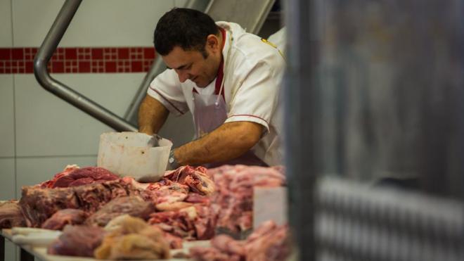 A butcher cuts meat at a butchery stall inside a market in Sao Paulo, Brazil, on Saturday, March 18, 2017.