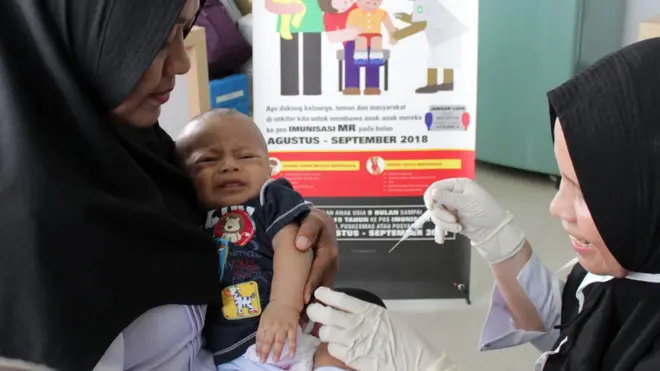 Petugas menyuntikan Vaksin Campak dan Rubella (MR) kepada bayi saat dilakukan imunisasi di Puskesmas Darussalam, Banda Aceh, Rabu (19/09).