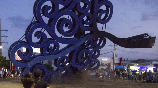 Manifestantes que protestan contra el gobierno derriban uno de los árboles de la vida en Managua.