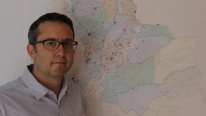 Natalio Cosoy junto al mapa que hay en la oficina de la corresponsalía de BBC Mundo en Colombia.