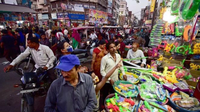 People crowd at a roadside shop to buy water pistols used in the upcoming Holi celebrations, which is a popular Hindu spring festival of colours in Allahabad on March 27, 2021.