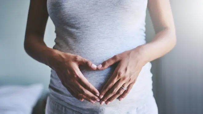 Imagem aproximadapixbet brasil commulher grávida com mão na barriga