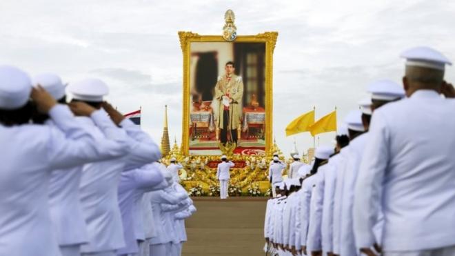 Thai officials pay respect next to a picture of Thailand"s King Maha Vajiralongkorn outside the Grand Palace in Bangkok