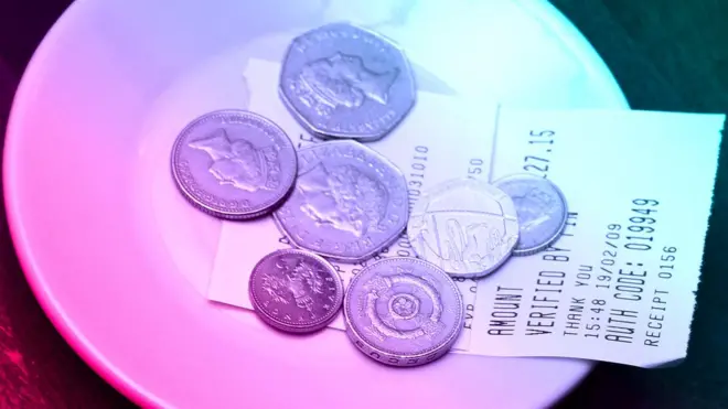 Coins on top of a receipt left for a tip