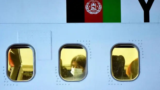 విమానంలో నుంచి బయటకు చూస్తున్న అఫ్గాన్ ప్రయాణీకురాలు