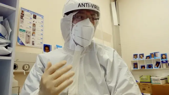 Волонтер в защитном костюме