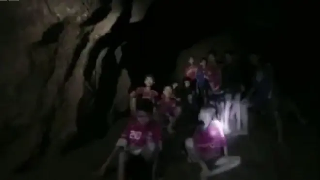 กลุ่มเด็กนั่งอยู่ในถ้ำ