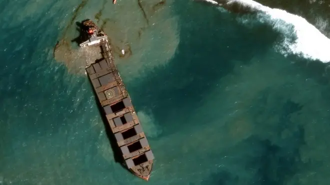 The ship's bow is being towed away from the reef